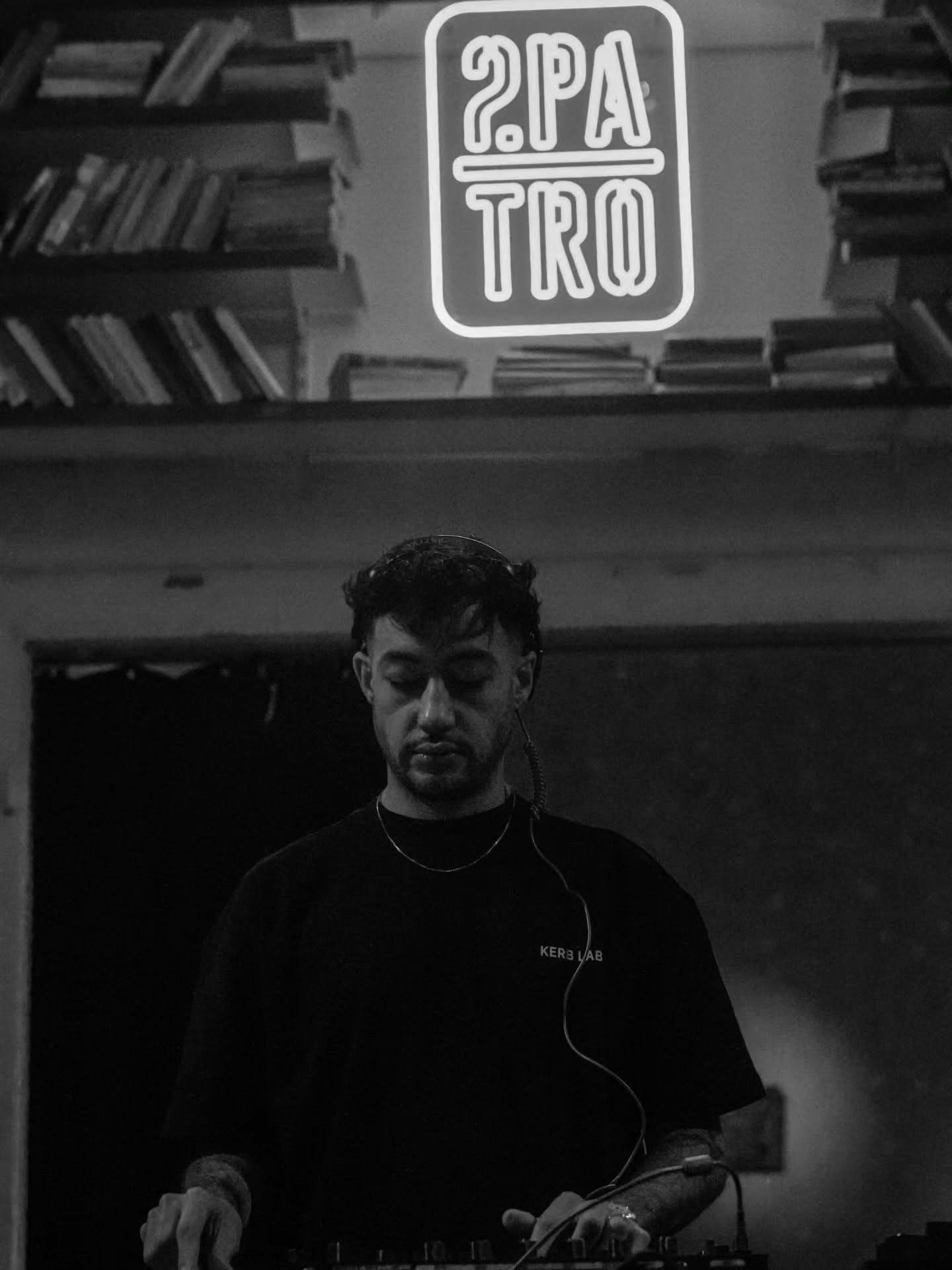 DJ performing under a neon sign in a bar