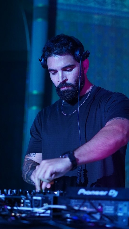 DJ mixing under blue stage lighting