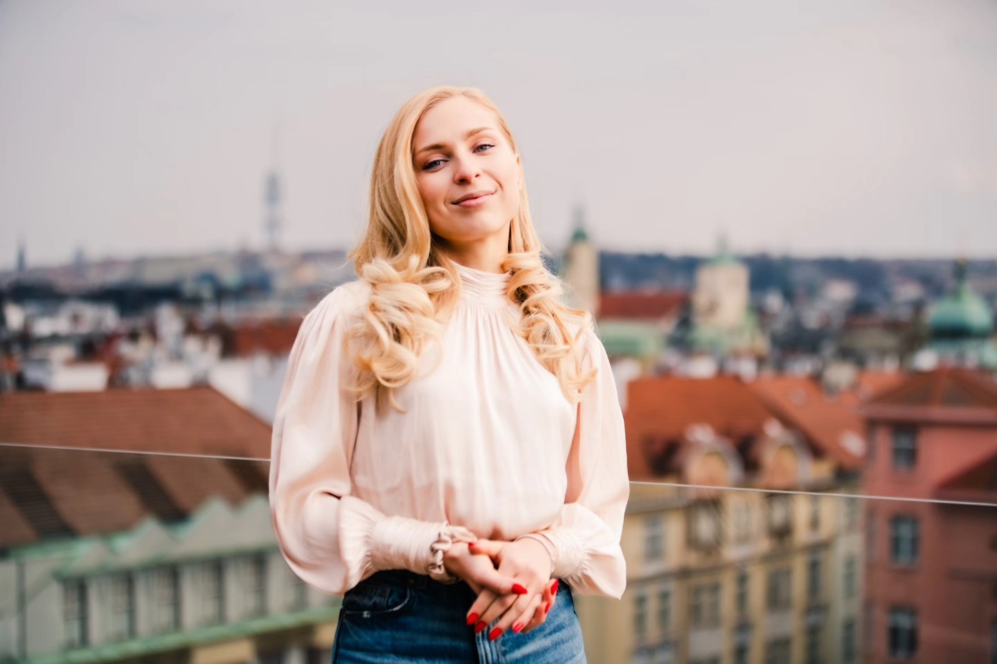 Portrait of a woman with a Prague rooftop skyline