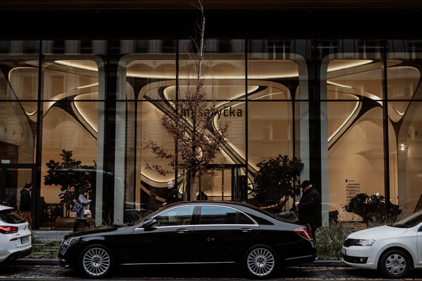 Chauffeured car outside a Prague storefront at dusk
